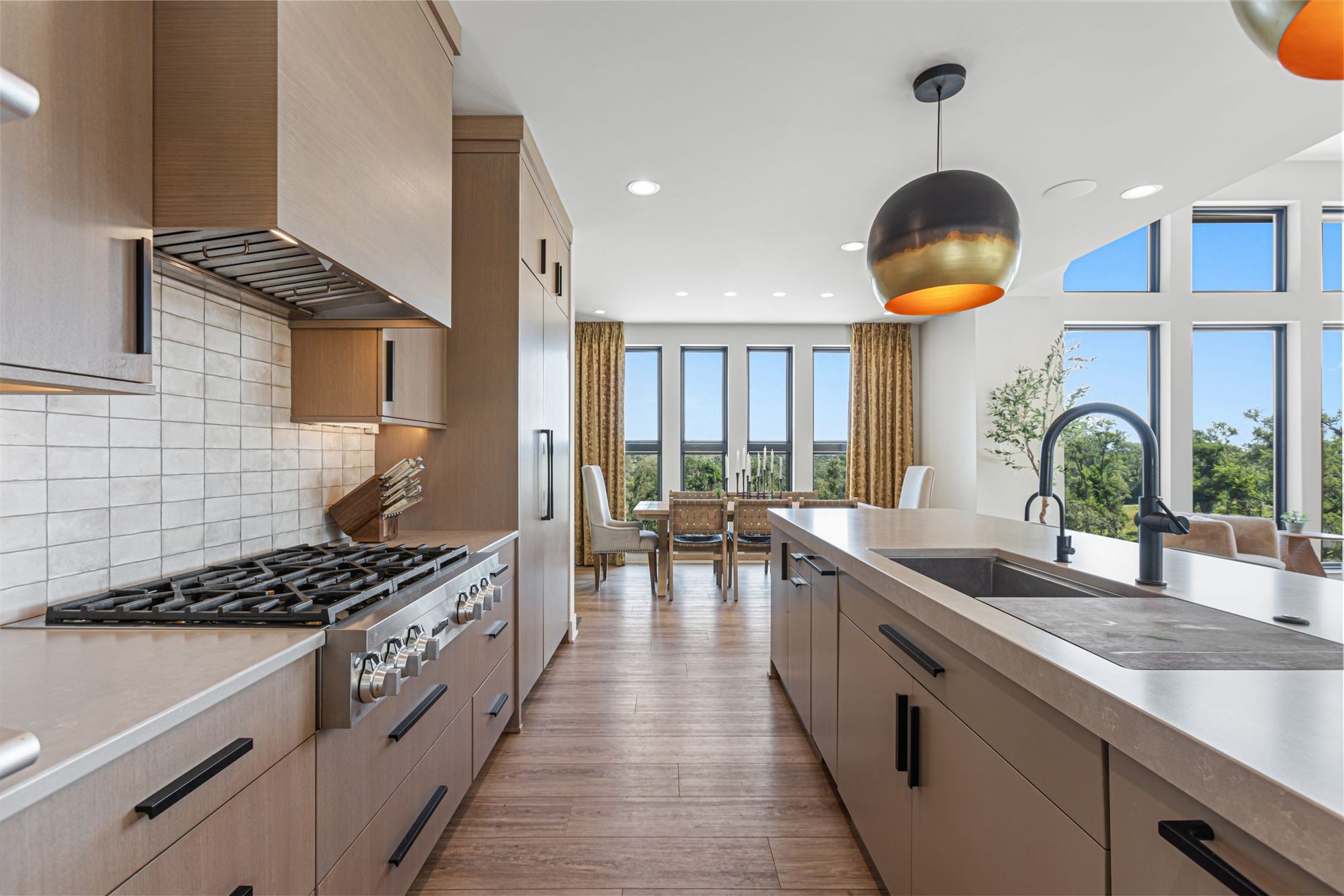 Range wall with white tile and light-oak cabinetry