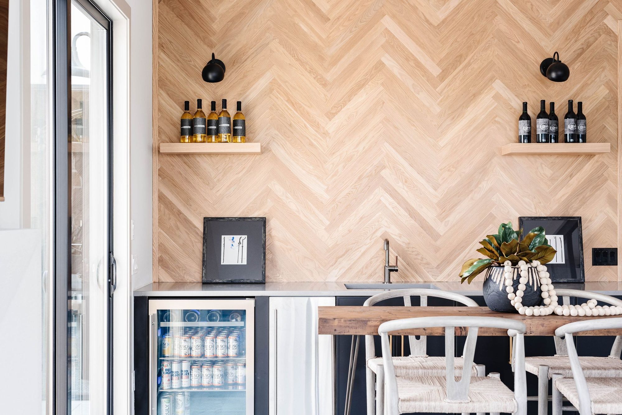 Wet bar with herringbone white-oak wall and beverage center