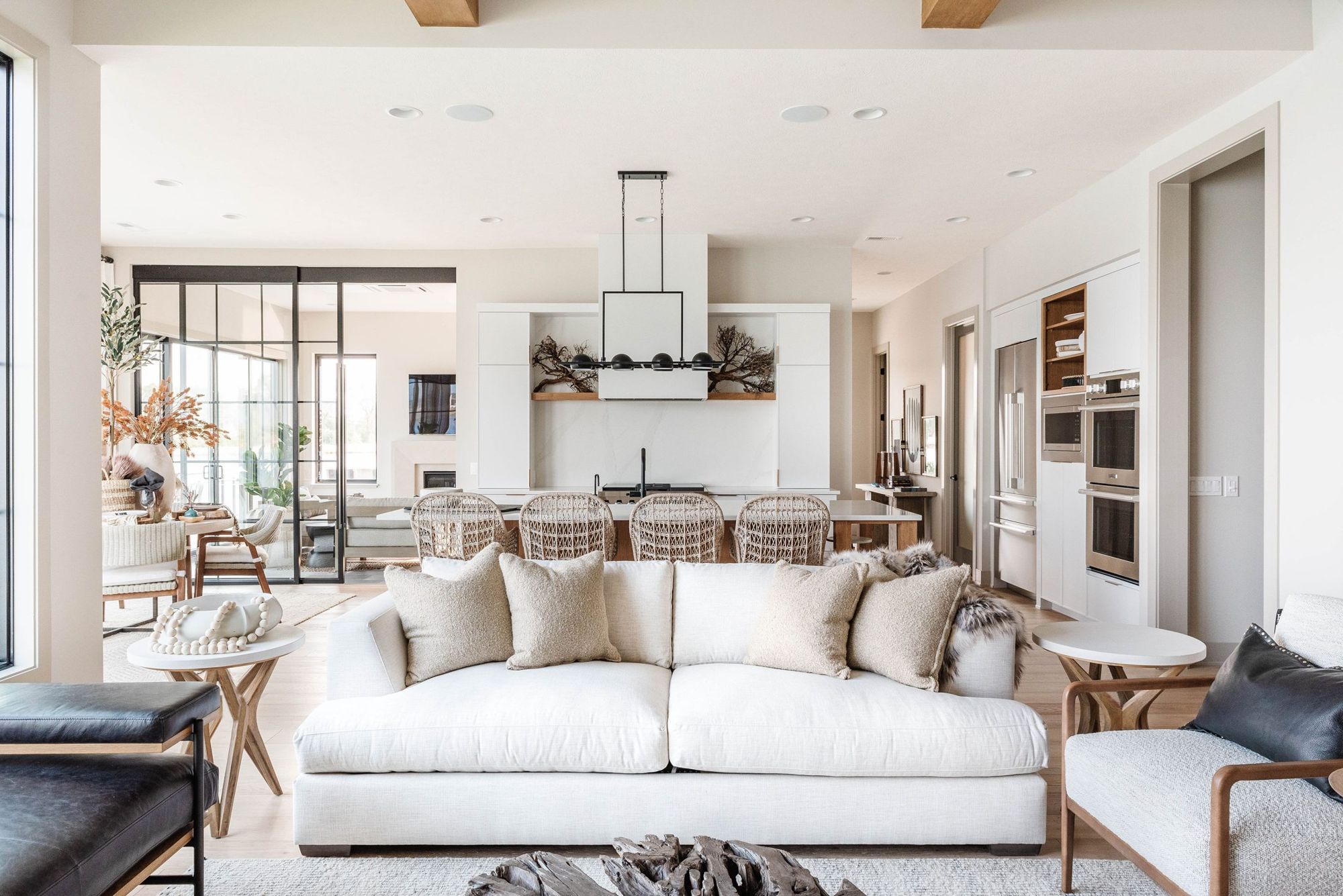 Great room with white sectional, open to the kitchen through steel-framed glass