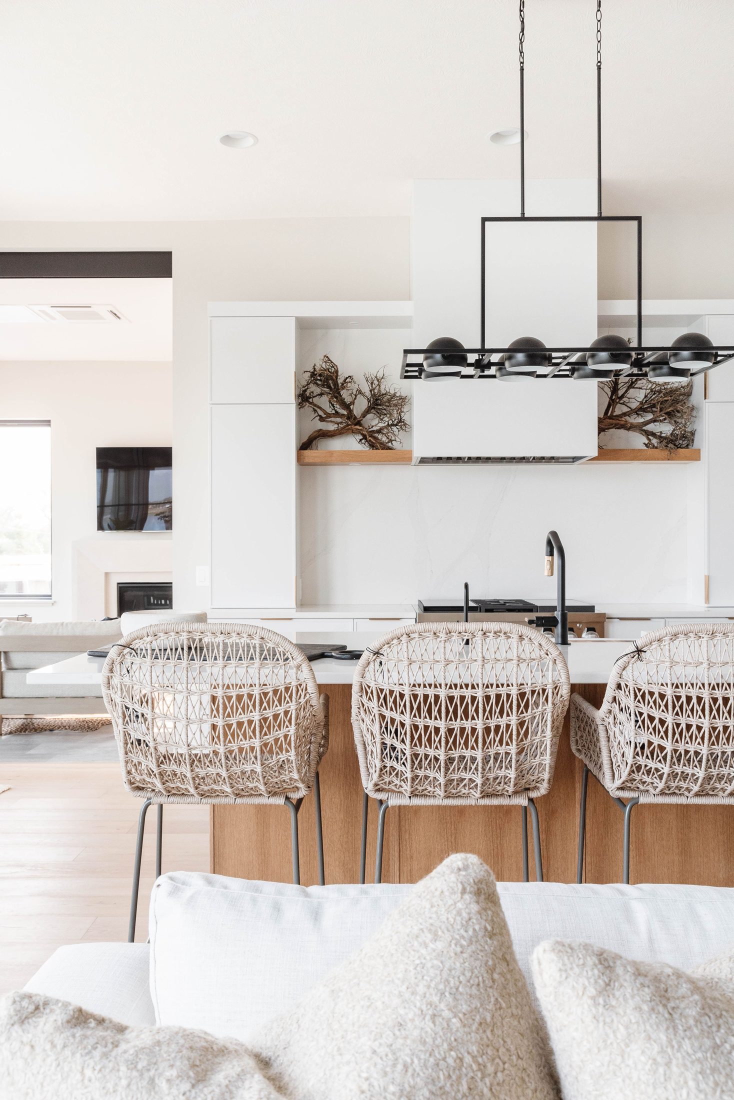 Kitchen island with rattan counter stools and matte black fixtures