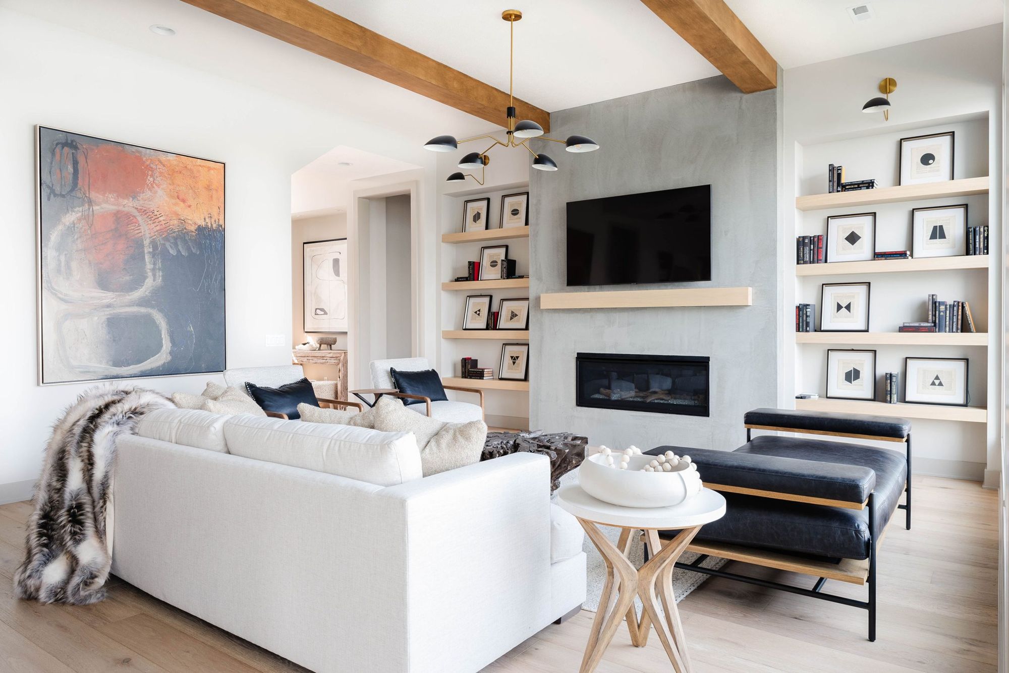 Living room with linear fireplace, built-in shelving and leather chaise
